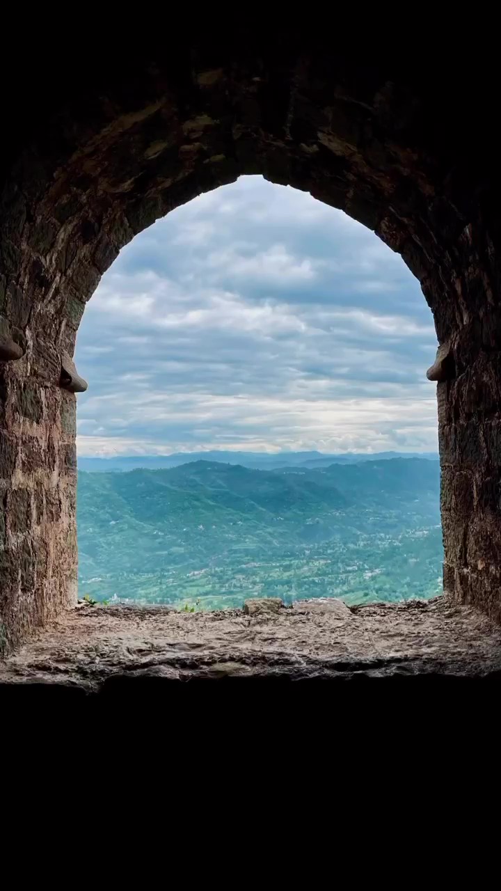 View of the Shivalik hills through an arched fort window